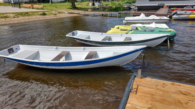 View of several small boats at a marina on a calm river.