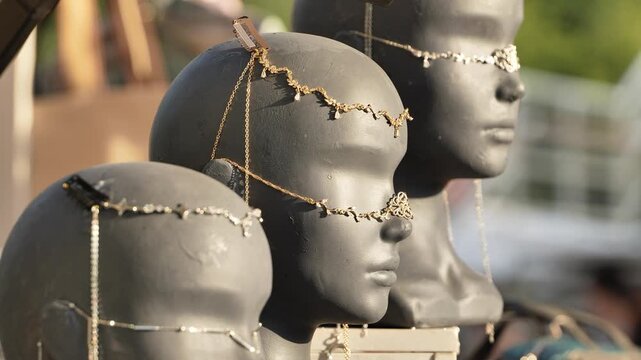 Mannequin heads showcasing elegant hair jewelry, chains, and ornaments for sale