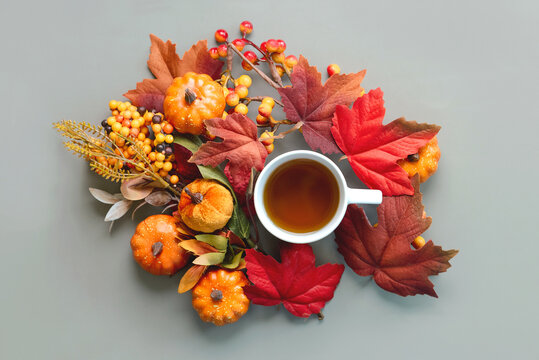 Top view of cup of tea with pumpkins and autumn leaves. Autumn concept background