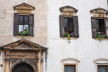 Obraz premium Picturesque old building facade in a European town, showcasing vintage architecture, stone molding, and rustic shutters.