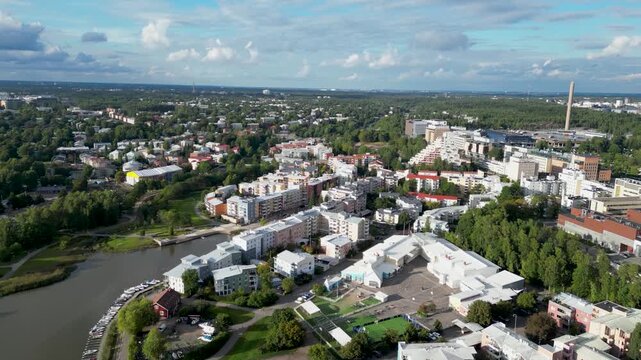 Pikku-Huopalahti, Helsinki, Finland. Aerial drone view of the residential area with colorful apartment buildings, green spaces, roads, and surrounding urban landscape.