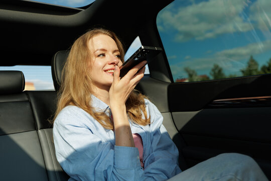 Woman Using Smartphone Voice Assistant While Riding In Car