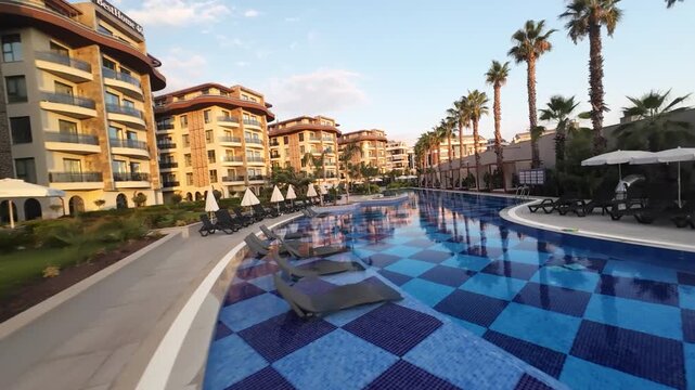 Resort Pool Surrounded by Palm Trees and Buildings