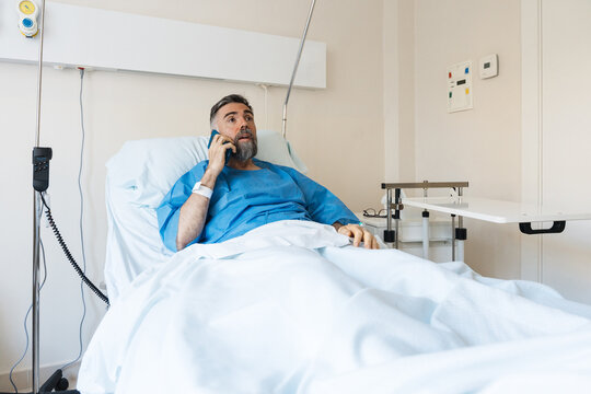 Patient man making phone call from hospital bed