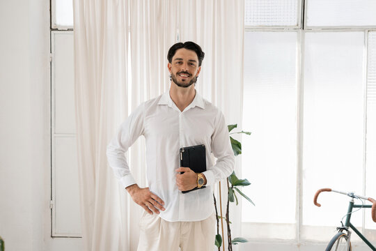 Young professional man smiling holding digital tablet