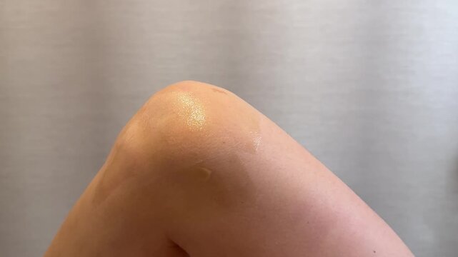 Close view of a young womans bent knee and smooth leg skin after cosmetic care, depilation and hair removal procedure in a beauty salon. Close up.