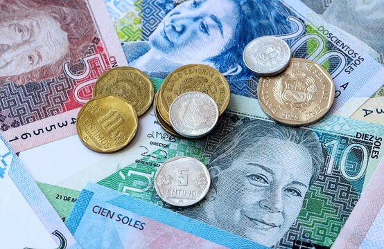 Peruvian sol money banknotes and coins on table. Peru cash bills of PEN currency