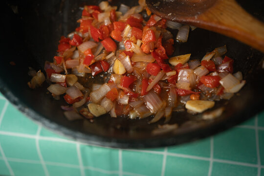 Saut&eacute;ing Diced Onions Red Peppers and Garlic in Wok Pan Close Up