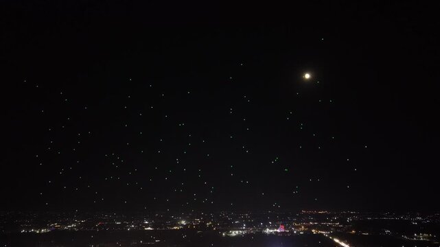 Aerial drone view of a spectacular drone light show spelling the word Syria at night. Illuminated drones forming glowing letters in the dark sky. Aerial entertainment celebrating Syrian heritage. Nigh