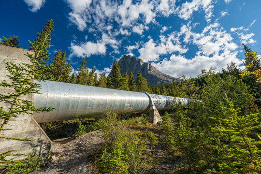 Big metal hydro power pipeline in forest connecting Whitemans Pond and Rundle Forebay. Canmore, Alberta, Canada.