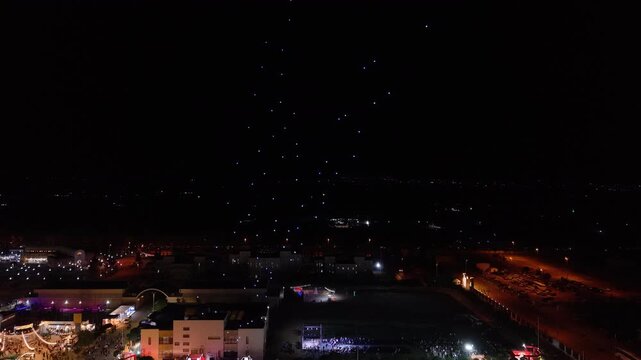 Aerial drone view of a spectacular drone light show spelling the word Syria at night. Illuminated drones forming glowing letters in the dark sky. Aerial entertainment celebrating Syrian heritage. Nigh