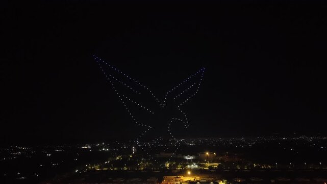Aerial drone view of a spectacular drone light show spelling the word Syria at night. Illuminated drones forming glowing letters in the dark sky. Aerial entertainment celebrating Syrian heritage. Nigh