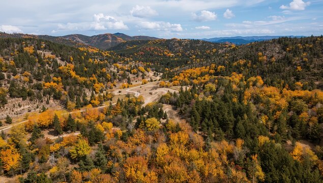Vista a&eacute;rea de pueblo entre colinas y bosques oto&ntilde;ales con colores c&aacute;lidos