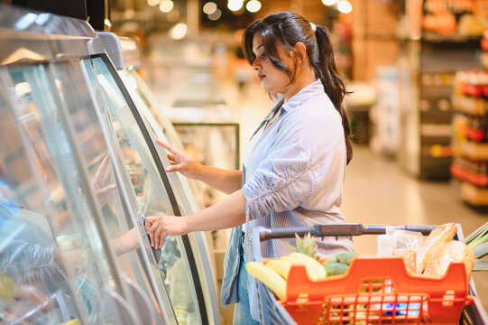 Woman shopping for fresh food in supermarket aisle