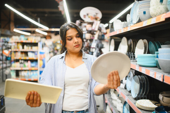 Indian woman choosing kitchenware in supermarket