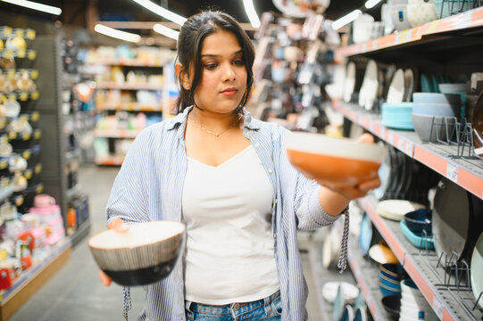 Woman choosing bowls in kitchenware department store