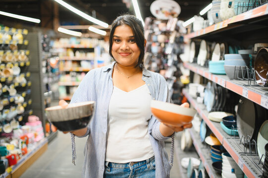 Indian woman choosing kitchenware in supermarket aisle