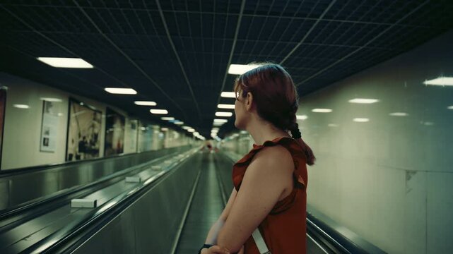 A female tourist walks on a moving walkway in the Naples metro