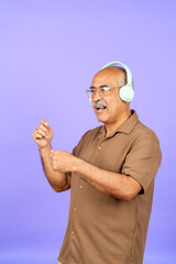 Fototapeta premium Senior man enjoying music with headphones dancing
