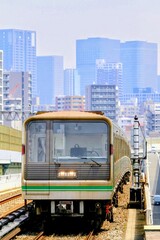 Fototapeta premium 高層ビル群を背景に高架線を走る電車