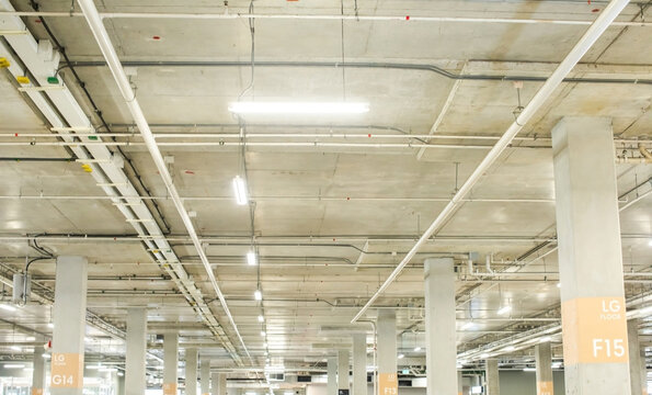 Selective focus to Exposed Concrete Ceiling and blurry Pipes in Underground Parking Garage.
