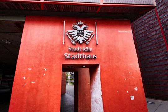 Cologne, Germany  August 31 2026: Red entrance structure of the Cologne Stadthaus municipal building with official city coat of arms and sign in Cologne-Deutz