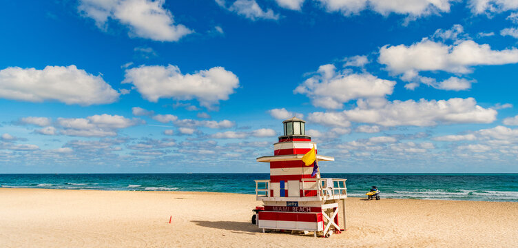 Lifeguard tower on the sandy Miami Beach shore. Iconic Art Deco lifeguard station under summer sky. Scenic view of South Beach coastline in Florida. Colorful lifeguard tower, symbol of Miami tourism.