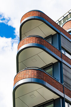Balcony of apartment. Architectural building in neighborhood. Suburb exterior with private balcony. Condominium architecture. Balcony of residential building. Residential house