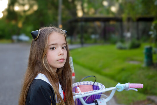 Young girl with long brown hair, wearing cat ears