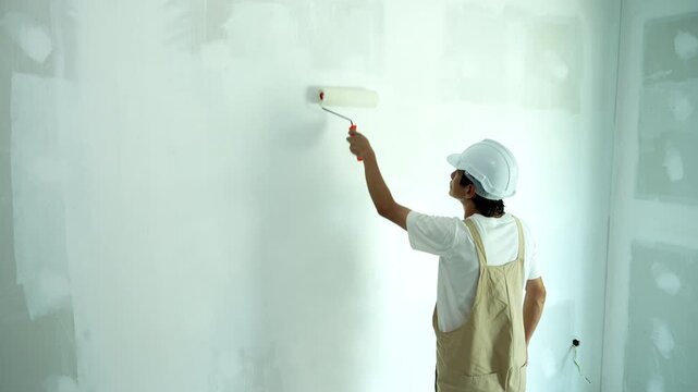 painter man, brush in hand for products to restore and paint the wall, indoor the building site of a house, wall during painting, renovation, painting, contractor, Architect, construction worker