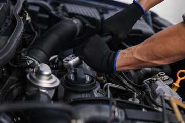 Fototapeta premium Professional mechanic with wrench fixing car indoors, closeup