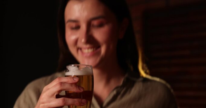 Friends clinking glasses of beer indoors, closeup. Camera moving in and out