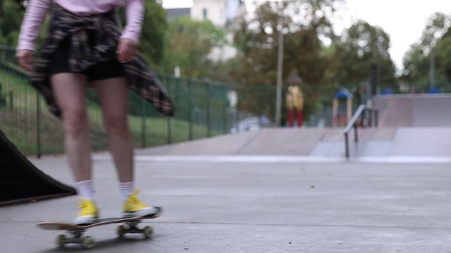 Stylish woman riding skateboard in skate park