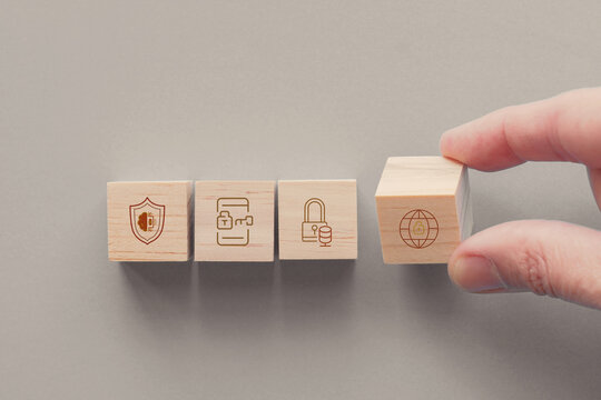 Hands holding wooden blocks with icons, cyber security, risk management, business concept
