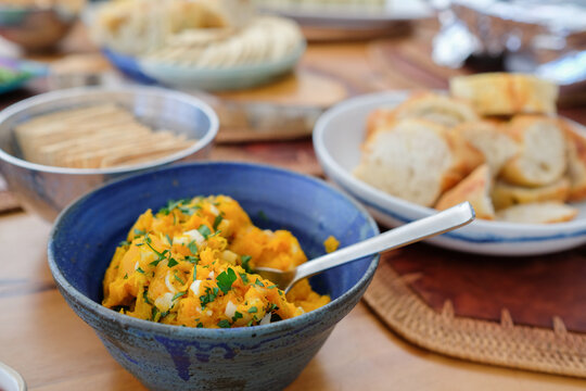 pumpkin dip, mashed squash, appetizer, roasted pumpkin, healthy spread, vegan food, party platter featuring fresh baguette slices and crackers on a rustic wooden table setting.
