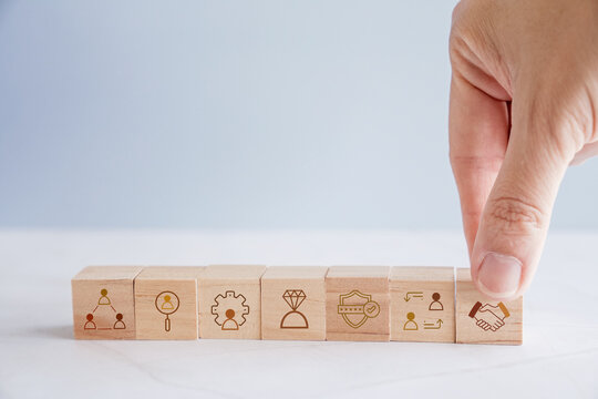 Hand holding wooden blocks with HR icons, human resource management, recruitment hiring business concept
