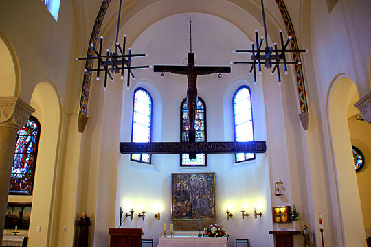 BUDAPEST, HUNGARY - AUGUST 31, 2025: Interior of the Jak Chapel. The main altar features a crucifix and a central religious icon, illuminated softly by stained glass light, exuding sacred elegance