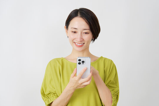 スマホを使うミドル女性　白背景