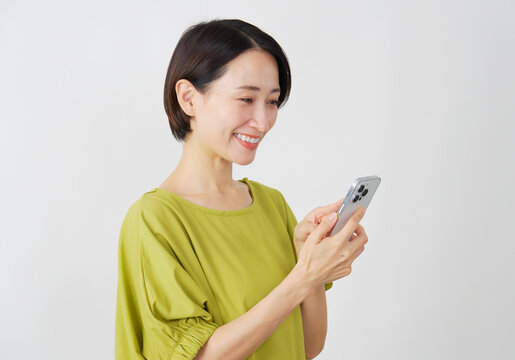 スマホを使うミドル女性　白背景