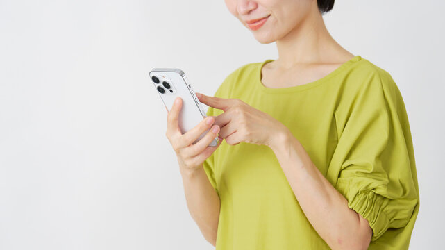 スマホを使うミドル女性　白背景　顔なし
