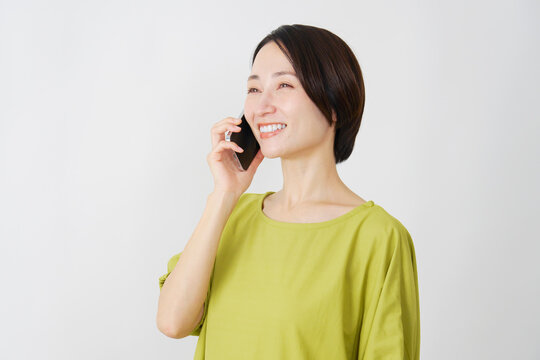 スマホで電話するミドル女性　白背景