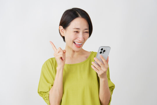 スマホを持ってひらめくミドル女性　白背景