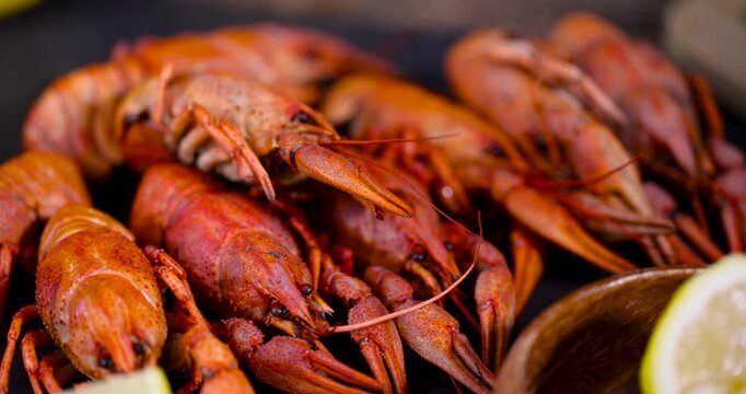 Background of boiled red crayfish on a dark plate, a group of hot boiled crayfish with an orange shell served on a flat tray