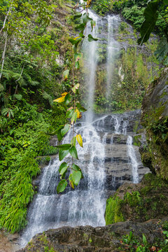 The picturesque cascading Nanchiquim Falls cascades over a stepped rocky cliff surrounded by lush green tropical vegetation in Limon Indanza, Morona-Santiago, Ecuadorian Amazon.