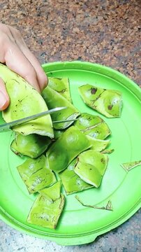 Cutting Petai Stink Beans with Scissors for Food Preparation