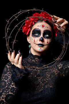 Halloween beauty portrait of woman. Female face with Santa Muerte makeup and barbed wire.
