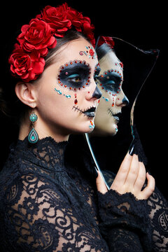 Halloween beauty portrait of woman with Santa Muerte makeup. Female with a shard of the mirror.