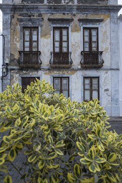 Weathered fa&ccedil;ade of an empty house in Garachico, characterized by crumbling plaster, old wooden doors and wrought-iron balconies, a silent testimony of past times, Garachico, Tenerife, Canary Islands, Spain