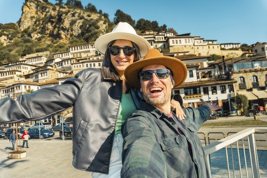 Portrait Joyful heterosexual couple looking at camera taking selfie photo laughing enjoying spring vacation get away holidays in Berat, Albania. Concept connection, happiness, freedom, fun, bonding