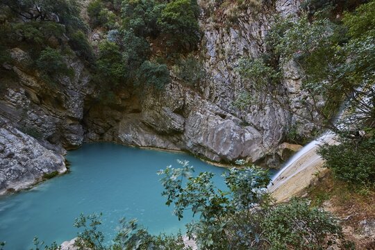 A rocky gorge with a small waterfall, turquoise water and thick vegetation, waterfalls, ponds, Polylimnio, Peloponnese, Greece
